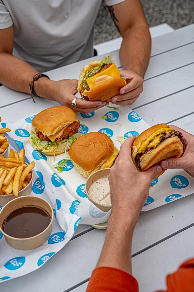 Friends sharing Dip It burgers at Nomad Brewing Brookvale